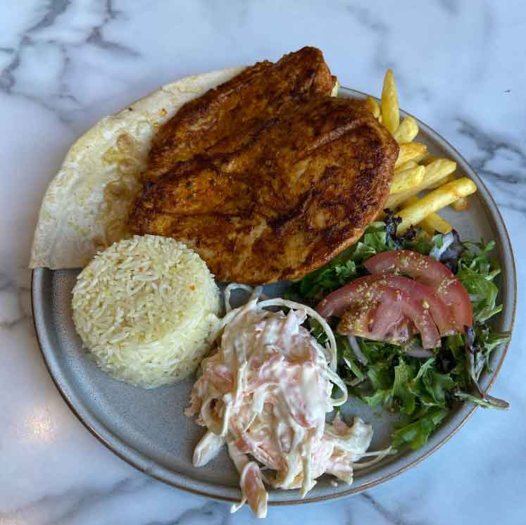 Ada’s grilled chicken, French fries, rice, a small salad, and coleslaw.