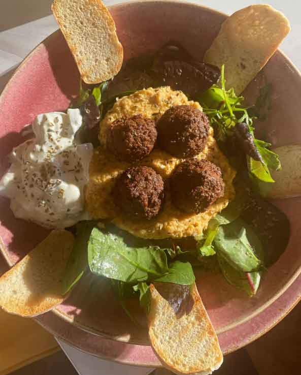 Ada’s falafel plate with hummus, a side of yoghurt, and a small green salad.i